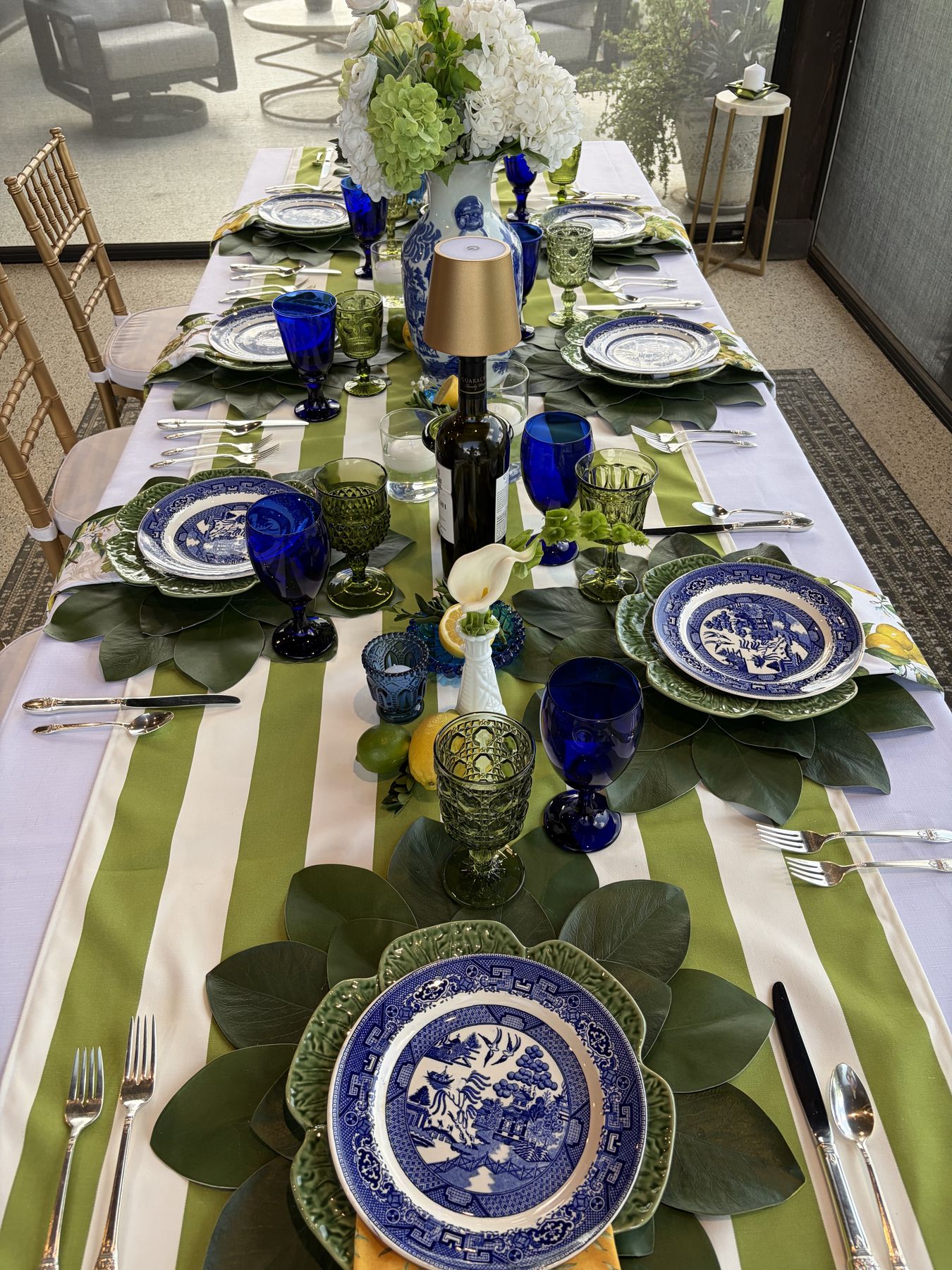 Green and white chinoiserie table with striped linen